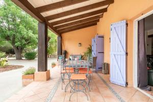 eine Terrasse mit Tisch und Stühlen und einer blauen Tür in der Unterkunft Villa Laforge in Carmona