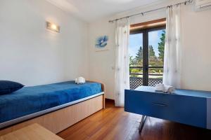 a bedroom with a blue bed and a balcony at Arrancada 7 in São Lourenço +19 photos