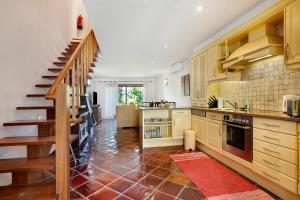 a kitchen with wooden cabinets and a staircase in it at Arrancada 7 in São Lourenço