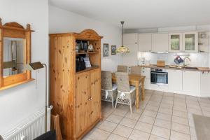 a kitchen with white cabinets and a table with chairs at Deichblick in Böhl