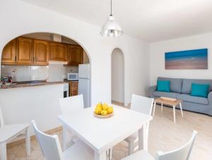 a kitchen and living room with a white table and chairs at Girasol Garden Superior 2-b in Menorca
