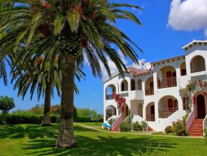 a palm tree in front of a house at Girasol Garden Superior 2-b in Menorca