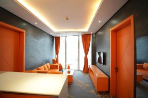 un soggiorno con mobili arancioni e una grande finestra di HUAZHU LUYI Service Apartment 华住庐艺 a Riyad