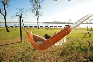eine Frau, die in einer Hängematte auf einem Feld liegt in der Unterkunft Casa na Represa do Broa - Condomínio Vila Pinhal in Itirapina + 12 Fotos