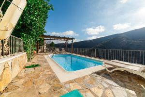 a swimming pool with a bench next to a fence at El Mirador in Laroya