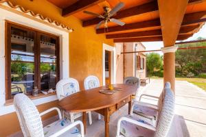a dining room with a wooden table and white chairs at Can Me Sents in Pollença