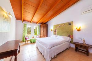a bedroom with a bed and a wooden ceiling at Can Me Sents in Pollença +30 photos