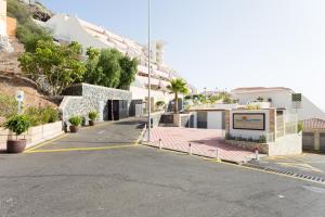 an empty street with a fence and buildings at Sunset Costa Adeje Oceanview in Adeje