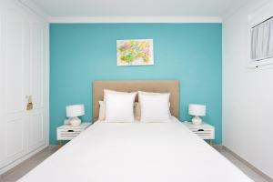 a bedroom with a large white bed with blue walls at Sunset Costa Adeje Oceanview in Adeje +24 photos