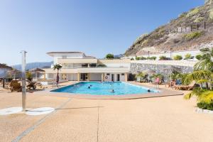 a large building with a swimming pool in front of it at Sunset Costa Adeje Oceanview in Adeje
