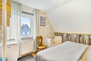a bedroom with a bed and a chair and a window at Yalet Ferienhaus in Brilon