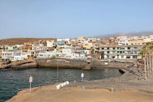 a group of buildings in a town next to the water at Mi refugio en La Jaca in Arico