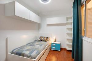 a bedroom with white walls and a bed with a blue nightstand at Mi refugio en La Jaca in Arico