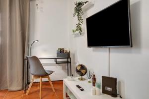 a living room with a chair and a tv on a wall at Mi refugio en La Jaca in Arico