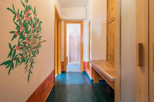 a hallway with a plant mural on the wall at App Oleandro Casa Demonti in Tignale +24 photos