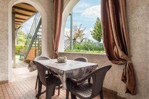 a dining room with a table and chairs and a window at App Oleandro Casa Demonti in Tignale