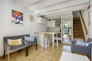 a kitchen and living room with chairs and a table at Ty Dacoli - piscine et plage in Le Pouliguen