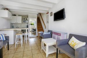 a living room with chairs and a kitchen with a counter at Ty Dacoli - piscine et plage in Le Pouliguen