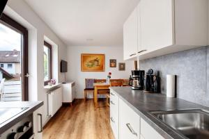 a kitchen with white cabinets and a table in it at Ferienwohnung In Bempflingen in Bempflingen +17 photos
