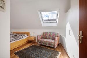 a bedroom with a bed and a chair and a window at Ferienwohnung In Bempflingen in Bempflingen