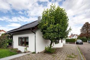 a small white house with a tree next to it at Ferienwohnung In Bempflingen in Bempflingen