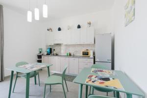 a kitchen with two tables and chairs and a refrigerator at Bed And Breakfast Champagneria in Castelvetrano Selinunte
