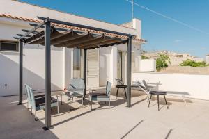 a pergola with chairs and a table on a patio at Bed And Breakfast Champagneria in Castelvetrano Selinunte