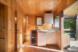 a kitchen with white appliances and wooden walls at Casa Bucaneve in Barzio +8 photos