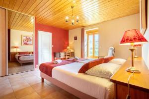 a bedroom with a large bed and a mirror at Maison Indépendante Sur Jardin in Mahalon