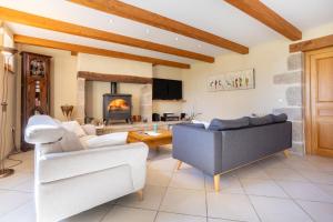 a living room with a couch and a fireplace at Maison Indépendante Sur Jardin in Mahalon