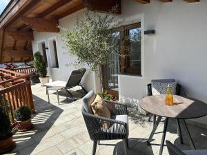 a patio with chairs and a table and a table and chairs at Residence Skutial App Santner in Castelrotto