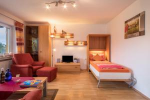 a bedroom with a bed and a living room at Ferienwohnung Steinhilber 2 in Eriskirch