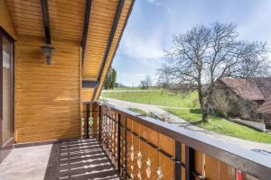 a view from the balcony of a house with a wooden wall at Ferienwohnung Camilla Wagner in Amtzell