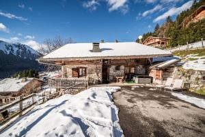 a log cabin in the mountains with snow on the ground at la ferme de la Vora in Châtel