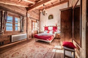 a bedroom with a red bed in a wooden room at la ferme de la Vora in Châtel