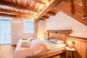a bedroom with a bed in a room with wooden ceilings at Chalet Osmar Appartamento 2 in Campitello di Fassa