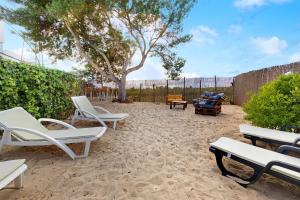 a patio with white chairs and a tree at Casa Syrah in Palmela