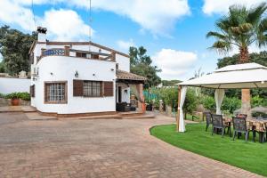 a white house with a patio and an umbrella at Villa Giovanni in Barbate