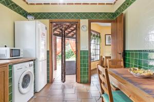 a kitchen with a table and a refrigerator at Villa Giovanni in Barbate
