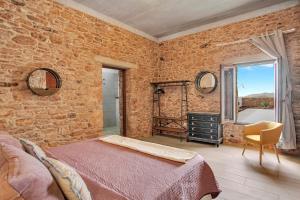 a bedroom with a brick wall with a bed and a window at Casa Rural Sajoná in Tiscamanita +31 photos