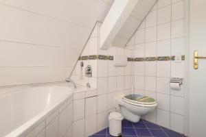 a bathroom with a toilet and a bath tub at Ferienappartement Pauli in Hagnau +14 photos