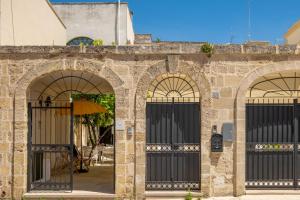 two entrances to a brick building with black gates at Dimora Egilò - Violet in Nardò