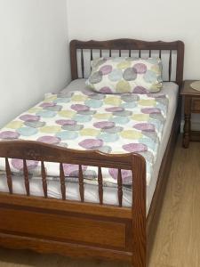 a bed with a wooden frame with a quilt on it at Ferienwohnung am Halbmond in Badbergen