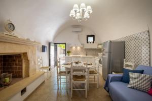 a kitchen and living room with a table and a refrigerator at Dimora Egilò - Violet in Nardò