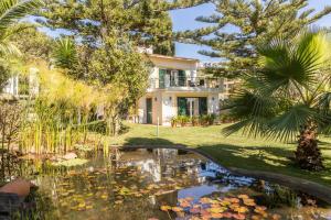 a house with a pond in front of it at Villa Echium T2 in Caniço