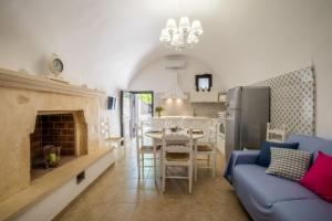 a living room with a blue couch and a kitchen at Dimora Egilò - Violet in Nardò +11 photos
