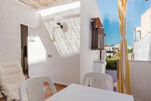 a white dining room with a white table and chairs at Sea Nest in Balestrate