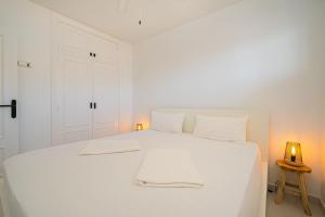 a white bedroom with a white bed with two white pillows at Costabella Altea in Altea