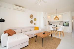 a living room with a white couch and a table at Costabella Altea in Altea