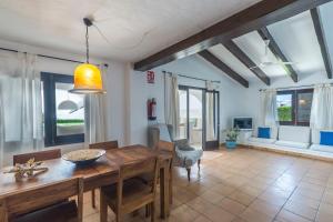 a dining room with a wooden table and chairs at Villa Bini Andu in Binibeca
